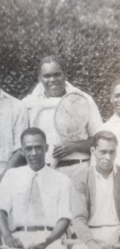 John entre otros tenistas negros del club de la Asociación Industrial y Cristiana de Hombres Jóvenes, una organización de la YMCA negra que el padre de John ayudó a fundar en la ciudad.
